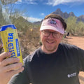 Person holding a can of iced tea with a scenic background