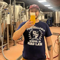 Man holding a glass of beer in a brewery setting