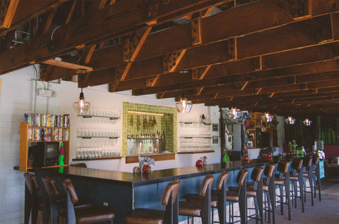 Bar area with wooden beams and shelves in a rustic setting