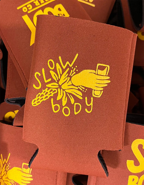 Red can coolers with yellow 'Slow Body' design on a matching background
